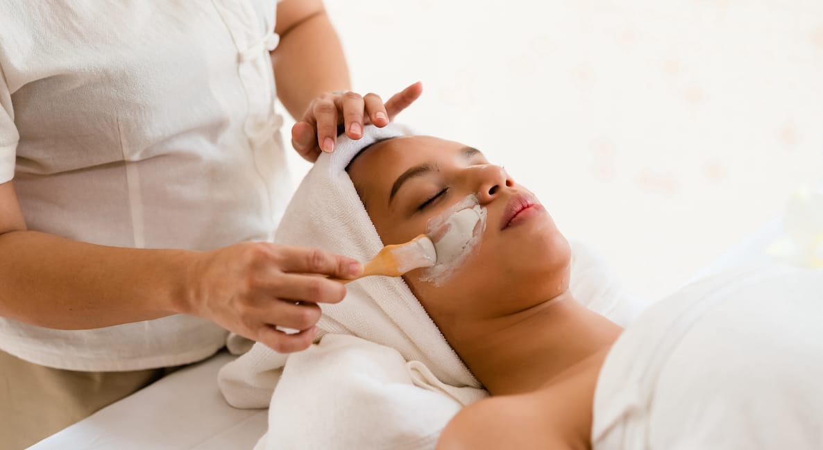 Woman getting a facial mask applied by spa therapist on a  Bali wellness retreat